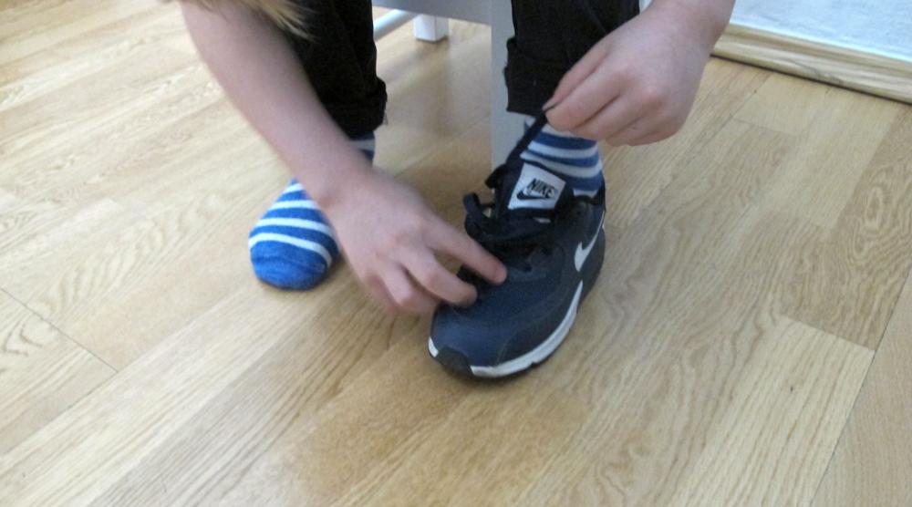 Junge bindet Turnschuhe Nike